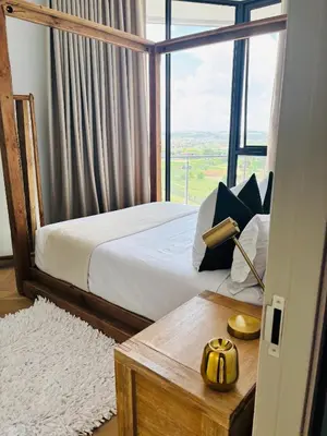 a bedroom with a bed and a large window at Thango Executives Gallileo Ellipse in Midrand