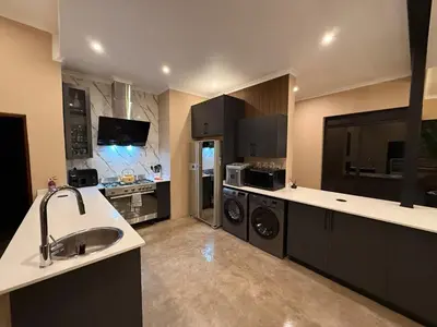 a large kitchen with a sink and a washer and dryer at Blessed Lodge at Ingilozi Mabalingwe in Warmbaths