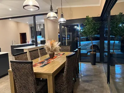 a dining room with a wooden table and chairs at Blessed Lodge at Ingilozi Mabalingwe in Warmbaths