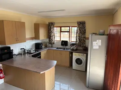 a kitchen with a refrigerator and a washing machine at Divine apartments in Polokwane