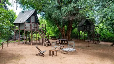 a playground with a tree house and a table and chairs at Pafuri Accommodation Rivercamp in Tshikuyu
