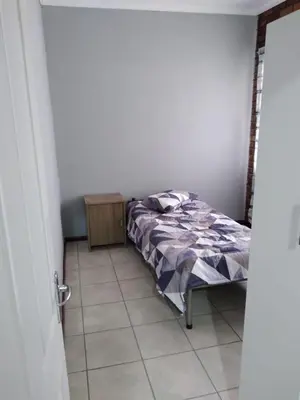 a bedroom with a bed and a tiled floor at The Pasture Loft in Mokopane
