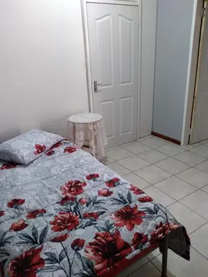a bedroom with a bed with a floral comforter at The Pasture Loft in Mokopane