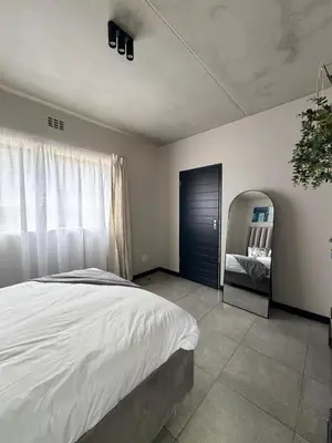 a bedroom with a large bed and a mirror at Sunset Sucasa in Midrand