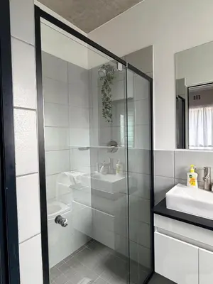 a bathroom with a glass shower and a sink at Sunset Sucasa in Midrand