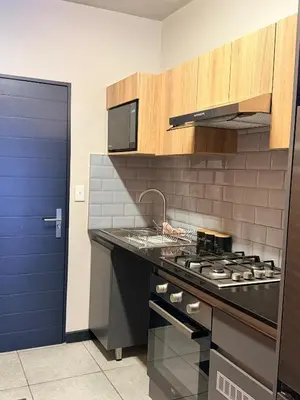 a kitchen with a stove and a blue door at Sunset Sucasa in Midrand