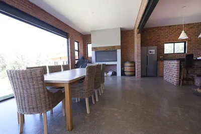a kitchen and dining room with a wooden table and chairs at Elements Private Golf Reserve 123 in Warmbaths