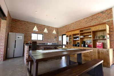 a kitchen with a wooden table and a brick wall at Elements Private Golf Reserve 123 in Warmbaths