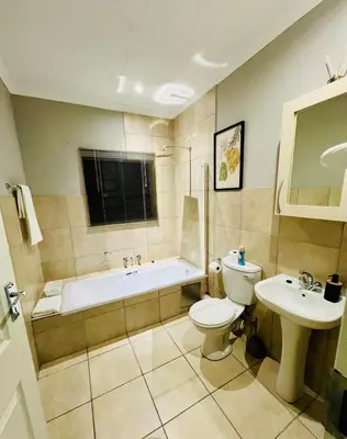 a bathroom with a tub and a toilet and a sink at The Wired Nest in Ellisras