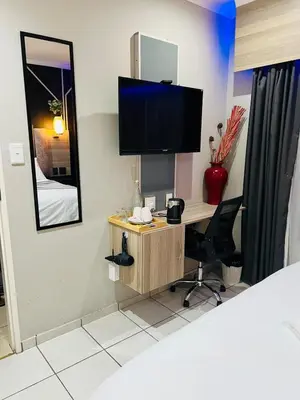 a room with a desk with a tv and a mirror at The Wired Nest in Ellisras