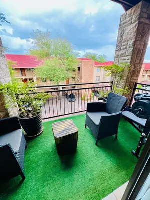 a balcony with chairs and a table on the grass at The Wired Nest in Ellisras