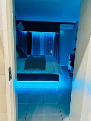 a bedroom with a bed with blue lighting at The Wired Nest in Ellisras