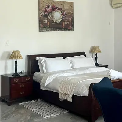 a bedroom with a bed with two night stands and two lamps at 165 Neptune Waterkloof Pretoria in Pretoria