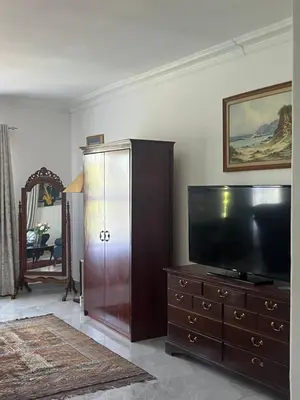 a living room with a tv and a wooden dresser at 165 Neptune Waterkloof Pretoria in Pretoria