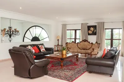 a living room with leather furniture and a table at 165 Neptune Waterkloof Pretoria in Pretoria