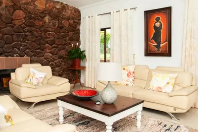 a living room with two couches and a table at 165 Neptune Waterkloof Pretoria in Pretoria