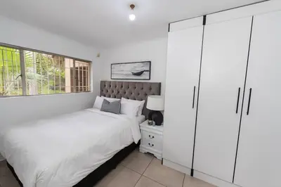 a bedroom with two beds and a closet at Serenity on Geelhaak in Kempton Park