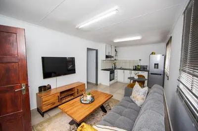 a living room with a couch and a table at Serenity on Geelhaak in Kempton Park