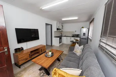 a living room with a couch and a table at Serenity on Geelhaak in Kempton Park