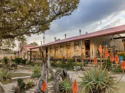 a building with orange flowers in front of it at John Jack Inn Accommodation in Lake Chrissie