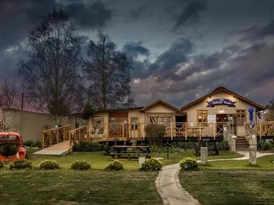 a large house with a porch and a playground at John Jack Inn Accommodation in Lake Chrissie