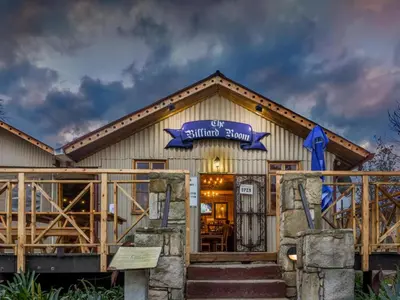 a log home with a sign on the front of it at John Jack Inn Accommodation in Lake Chrissie