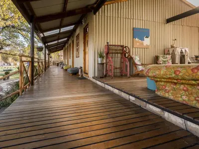 a porch with a wooden floor and a couch on it at John Jack Inn Accommodation in Lake Chrissie
