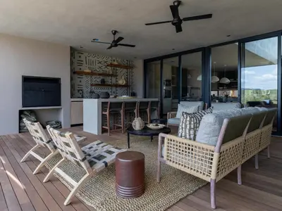 a living room with a couch and chairs on a deck at Izakithi River Villa in Malelane