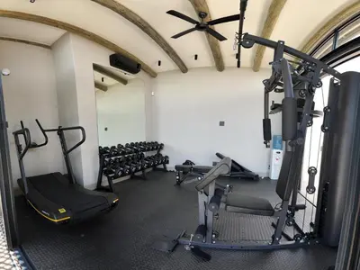 a gym with treadmills and machines in a room at Izakithi River Villa in Malelane