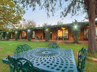a table and chairs in front of a house at Airport Bird & Game Lodge in Kempton Park