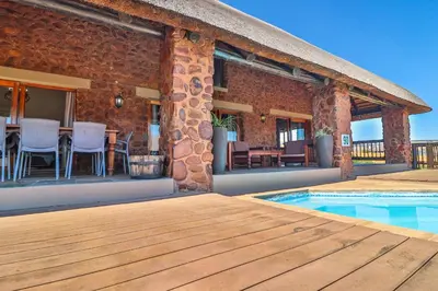 a brick building with a patio and a swimming pool at Doornkop Luxury 8 Sleeper with Private Pool and Boma in Carolina