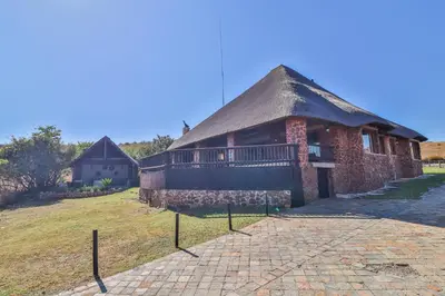 a large brick building with a thatched roof at Doornkop Luxury 8 Sleeper with Private Pool and Boma in Carolina