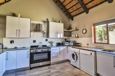 a kitchen with white cabinets and a dishwasher at Doornkop Luxury 8 Sleeper with Private Pool and Boma in Carolina