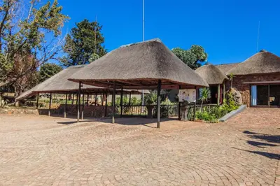a group of straw umbrellas on a brick road at Doornkop Luxury 8 Sleeper with Private Pool and Boma in Carolina