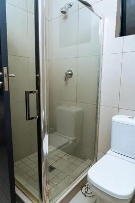 a shower stall in a bathroom with a toilet at Fully Equipped Modern 2-Bedroom in Midrand