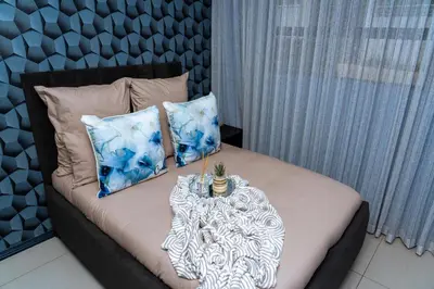 a bed with pillows and a table on it at Fully Equipped Modern 2-Bedroom in Midrand