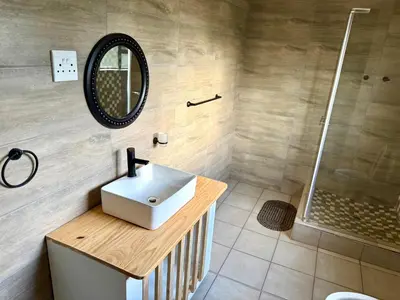 a bathroom with a sink and a shower at Grand Inn Hotel-Venda in Thohoyandou