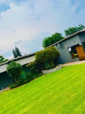 a house with a green lawn in front of it at QHAWEKAZI GUEST HOUSe in Witbank