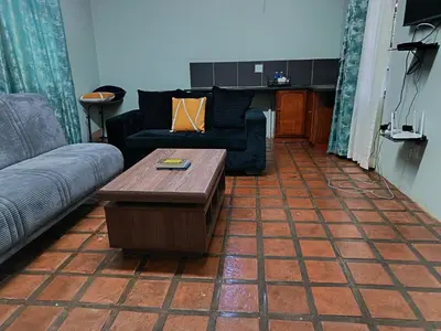 a living room with a couch and a coffee table at Villa De Lyden in Lydenburg
