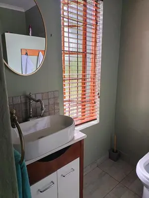 a bathroom with a sink and a mirror at Villa De Lyden in Lydenburg