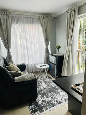 a living room with a couch and a table at Rugare Haven 2 in Kempton Park