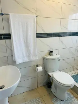 a bathroom with a white toilet and a sink at Rugare Haven 2 in Kempton Park