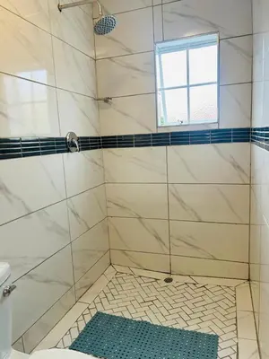a bathroom with a shower with a window at Rugare Haven 2 in Kempton Park
