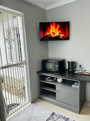 a living room with a tv and a fireplace at Rugare Haven 2 in Kempton Park