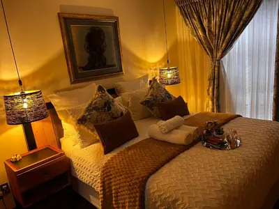 a bedroom with a large bed with two lamps at Mona Lisa No5 in Polokwane