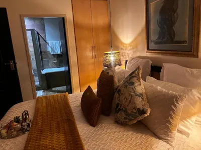 a bed with pillows and a lamp on it at Mona Lisa No5 in Polokwane