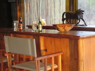 a wooden bar with a cow statue on top of it at Iphofolo Lodge & Tented Camp in Vivo