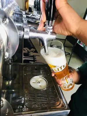 a person is holding a glass of beer at Iphofolo Lodge & Tented Camp in Vivo