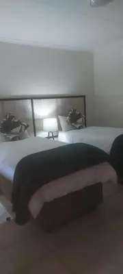 a bedroom with two beds and a lamp at Iphofolo Lodge & Tented Camp in Vivo