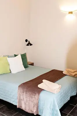 two beds in a room with towels on the bed at Pecan and Lime Inn The First Den in Pretoria